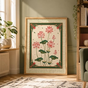 May include: A rectangular framed wall art piece featuring a cream-colored background with a central illustration of pink lotus flowers and green lily pads. The artwork is enclosed by a dark green border with floral accents in the corners.