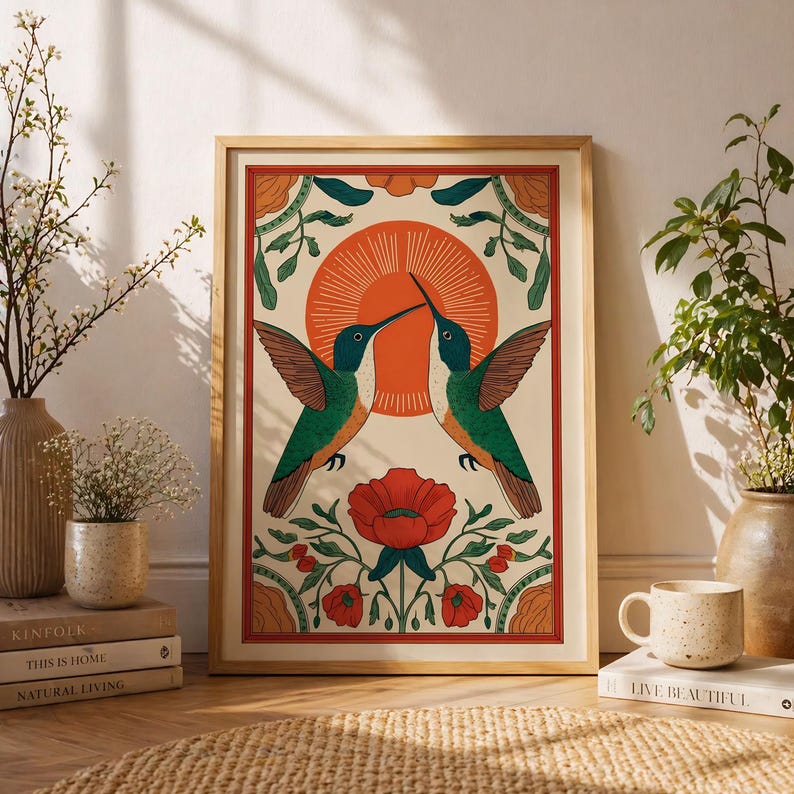 May include: A framed art print depicting two hummingbirds, green and brown, facing each other against a red sunburst. A red flower is at the bottom. The print is in a wooden frame, with a vintage aesthetic. The print is in a wooden frame.