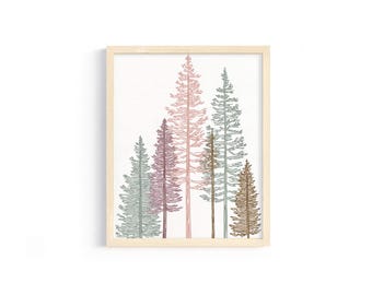 May include: A framed art print featuring a minimalist illustration of several stylized evergreen trees. The trees are rendered in shades of green, pink, and brown against a white background. The frame is made of light-colored wood.