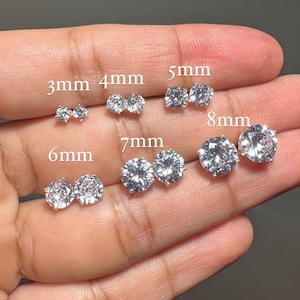 May include: A set of 10 pairs of silver stud earrings with clear cubic zirconia stones. The earrings are arranged in size order from 3mm to 8mm.