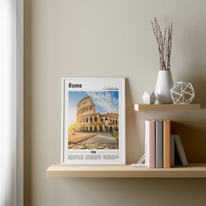 May include: A white framed print with a photograph of the Colosseum in Rome, Italy. The print has the words "Rome" and "Italy" at the top and "ROM" at the bottom.