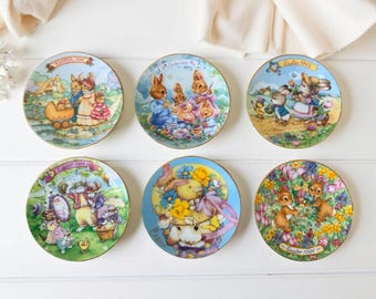 Coleção de pratos vintage Avon com coelhinho da Páscoa (1991–1996), detalhes em ouro 22 quilates, tons pastel de primavera, conjunto de colecionador com 6 peças.