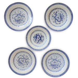 May include: Five white porcelain plates with blue dragon designs. Each plate features a central dragon motif, surrounded by intricate patterns and a blue border. The plates are arranged on a white background.