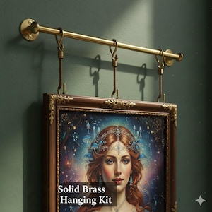 Pode incluir: Kit de suspensão em latão maciço com barra horizontal e ganchos decorativos, suportando uma obra de arte emoldurada. A obra apresenta um retrato de uma mulher ruiva sobre um fundo azul e roxo. O texto "Solid Brass Hanging Kit" é visível.
