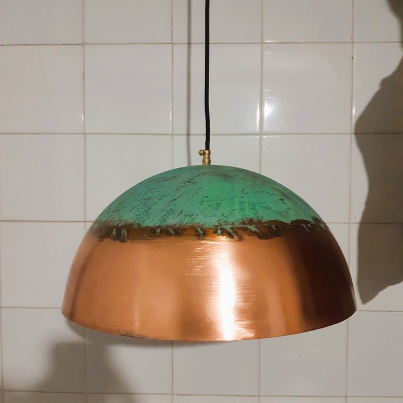 May include: A copper and green pendant light fixture with a dome-shaped shade. The top half of the shade is green with a distressed finish, and the bottom half is copper.