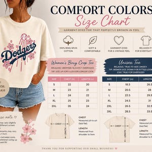 May include: Cream-colored t-shirt with a Dodgers baseball team graphic and floral accents. The image includes a size chart for both women's boxy crop tees and unisex tees, with chest and length measurements in inches. The shirt is made of 100% ring-spun cotton.