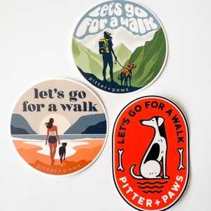 May include: Three round stickers with a dog and human walking in different settings. The stickers are red, orange, and green with the text "Let's go for a walk" and "Pitter + Paws".
