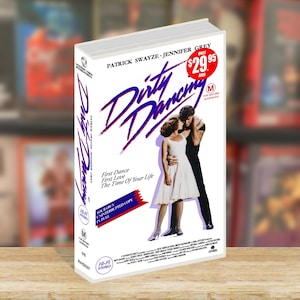 May include: A VHS tape of the movie "Dirty Dancing" featuring Patrick Swayze and Jennifer Grey. The cover art shows the couple embracing. The title is in a stylized purple font. The tape is labeled "M" for mature audiences.