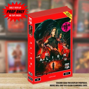 May include: A red VHS case for Alien Romulus featuring a movie poster with characters and a creature. The case includes text such as CBS FOX VIDEO, SCI-FI, HI-FI, and a price tag of $19.95. A starburst graphic states SHELF DISPLAY PROP ONLY NO TAPE INSIDE.