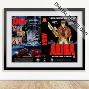 May include: Framed poster featuring the anime film "Akira." The poster has a black frame and displays the film's title in bold red letters. The artwork includes a character holding a weapon and scenes from the movie.