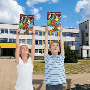 Two smiling elementary school children standing outside a school building, proudly holding The Language Theater grammar book above their heads against a bright blue sky.