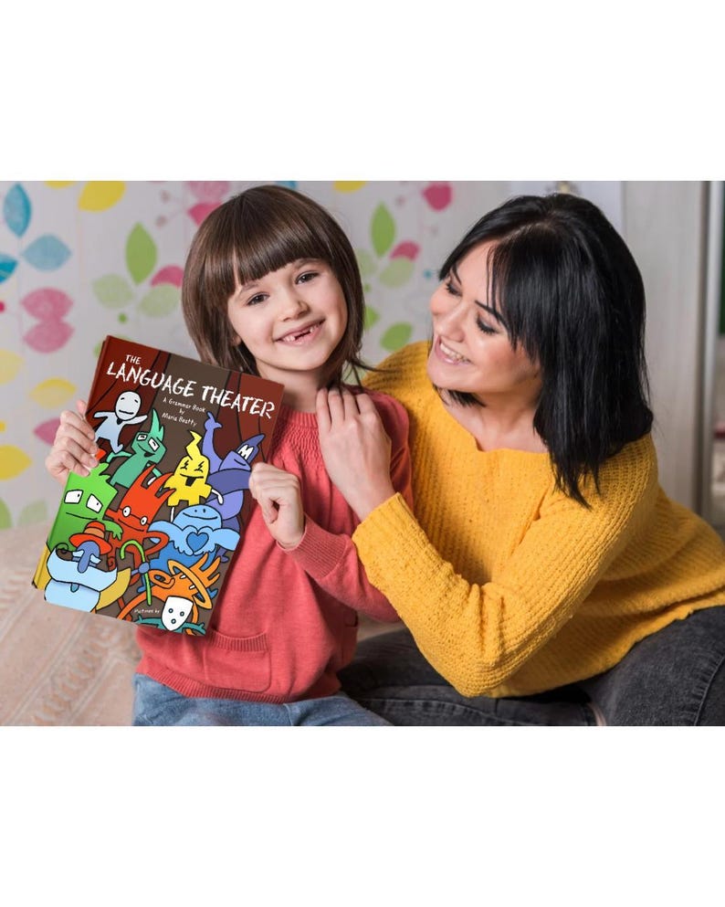 Smiling mother and daughter sitting together while the child proudly holds The Language Theater grammar book with its colorful character cover.