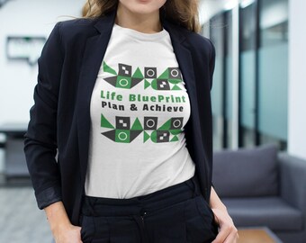 May include: White t-shirt with a geometric design in black and green. The text "Life BluePrint Plan & Achieve" is printed on the shirt.