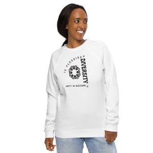 Könnte beinhalten: Weißer Pullover mit einem schwarzen Grafikdesign, auf dem "In planning diversity, unity in success" steht. Das Grafikdesign zeigt einen Kreis mit einem stilisierten Bild von Menschen, die sich an den Händen halten.