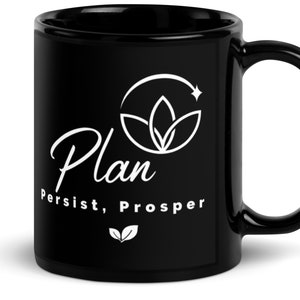 May include: Black ceramic coffee mug with a white design. The design features a stylized plant with a star and the text "Plan, Persist, Prosper".