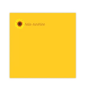 Puede incluir: Una nota adhesiva amarilla con un gráfico de girasol y el texto "hello sunshine" en cursiva marrón.