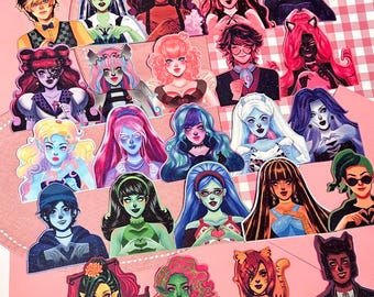 May include: A collection of colorful, stylized character stickers, each with unique hairstyles and outfits. The stickers feature a variety of skin tones and expressions, set against a pink background. The characters have a gothic or monster-themed aesthetic.