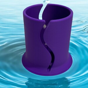 Op de afbeelding: Een paarse cilindrische houder met een verticale, S-vormige golvende gleuf aan de zijkant. Het object heeft een uitlopende basis en een gladde, matte afwerking, rechtop geplaatst in een blauw wateroppervlak met rimpelingen vanuit het midden.