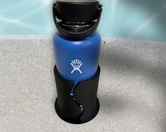 Könnte beinhalten: Eine blaue Edelstahl-Wasserflasche mit schwarzem Deckel und schwarzem Silikonhalter. Die Flasche hat ein weißes Logo mit einem vierzackigen Stern.