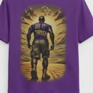 Puede incluir: Una camiseta morada de manga corta con un gráfico en la espalda de una persona caminando por un desierto hacia un sol brillante. La persona viste una camiseta morada con el texto "SEE IT THROUGH" impreso en la espalda y pantalones cortos cargo.