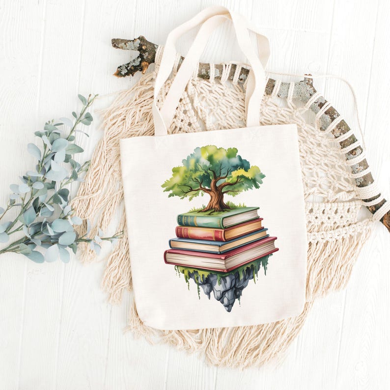 Puede incluir: Un bolso tote de color crema con una ilustraci&oacute;n en acuarela de un &aacute;rbol que crece de una pila de libros. El &aacute;rbol tiene hojas verdes y un tronco marr&oacute;n. Los libros son en tonos de rojo, naranja y verde. El bolso tiene asas color crema.