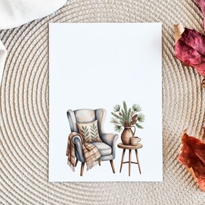 May include: Watercolor illustration of a cozy scene featuring a light blue armchair with a patterned pillow and a plaid throw. A small wooden side table holds a vase of pine branches and a cup. The background is white.