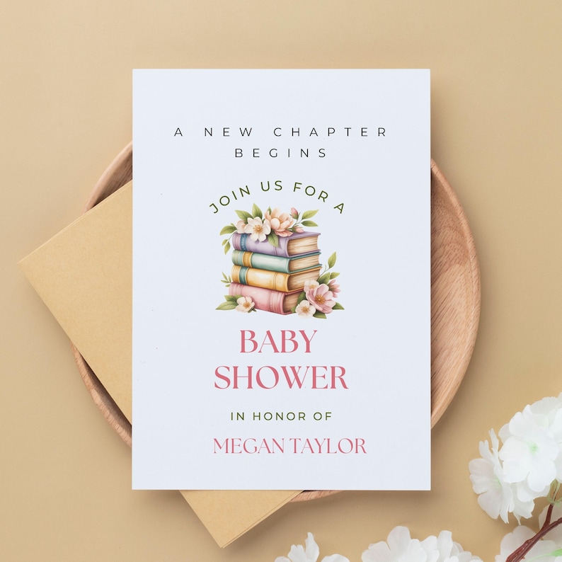 Puede incluir: Una tarjeta de invitaci&oacute;n para baby shower con el texto "A New Chapter Begins" y "Baby Shower" en rosa. La tarjeta presenta una pila de libros con acentos florales. La invitaci&oacute;n est&aacute; en una tarjeta blanca con un sobre beige.