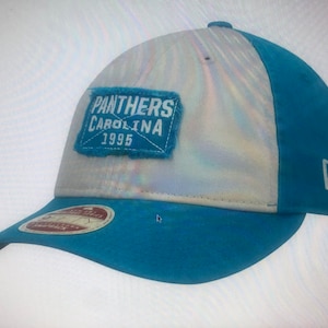 May include: A blue and white baseball cap with a patch that says "Panthers Carolina 1995".