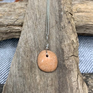 Minimalist necklace with cute, round, pink, natural rock pendant on 18-inch silver-colored chain.