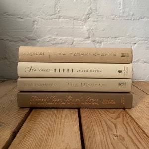 Taupe decorative books, taupe ivory and cream shelf decor, neutral interior design items, luxury book decor, prop staging styling books