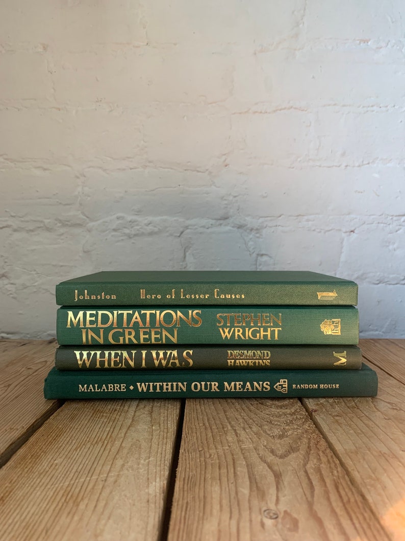 May include: A stack of four green hardback books with gold lettering. The titles are "Hero of Lesser Causes", "Meditations in Green", "When I Was", and "Within Our Means".