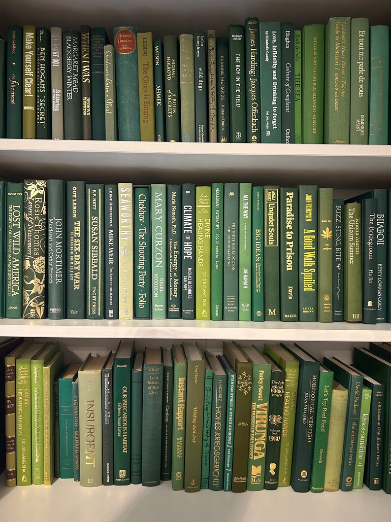 May include: A bookshelf filled with green and brown hardback books. The books are arranged in rows and are all different sizes. The books are all about different topics, including history, literature, and science.