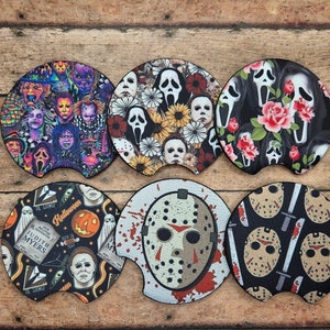 May include: Set of six car coasters with horror movie themes. Designs include a collage of horror characters, floral arrangements with ghost faces, and images of Jason Voorhees and Michael Myers.