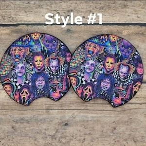 May include: Two car coasters with a colorful collage of horror movie characters. The coasters feature a black border and the text "Style #1". The design includes images of Michael Myers, Beetlejuice, and other iconic horror figures.