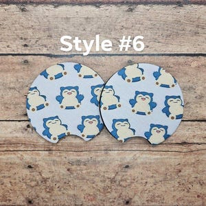 May include: Two white round drink coasters with a blue and white cartoon character design. The coasters feature a cartoon character with a blue body and a white face. The text "Style #6" is printed above the coasters.