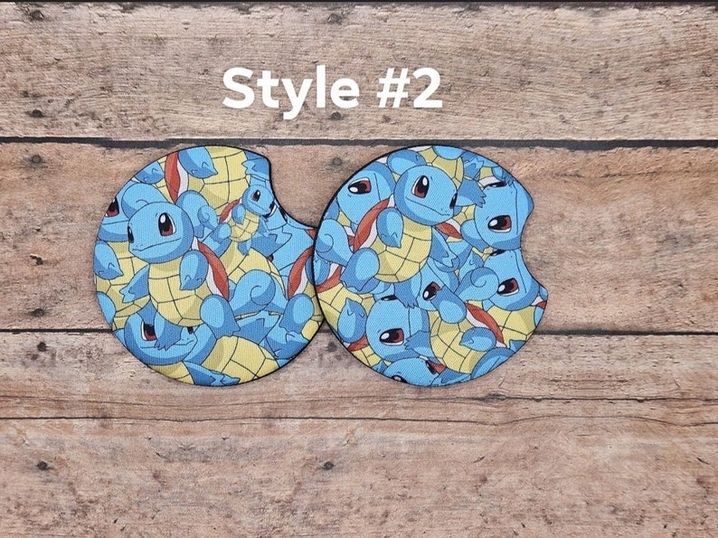 May include: Two round, blue and yellow car coasters with a repeating pattern of Squirtle, a Pokemon character. The text "Style #2" is above the coasters.