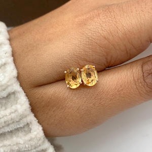 Puede incluir: Un par de pendientes de piedra preciosa amarilla ovalada con engaste dorado.
