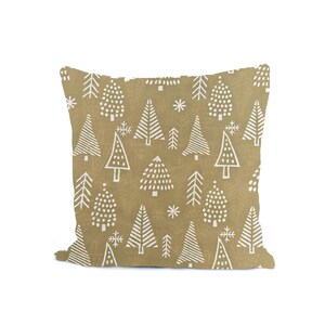 May include: A square decorative pillow with a repeating pattern of white Christmas trees and snowflakes on a tan background. The trees vary in style, some with dots, others with lines.