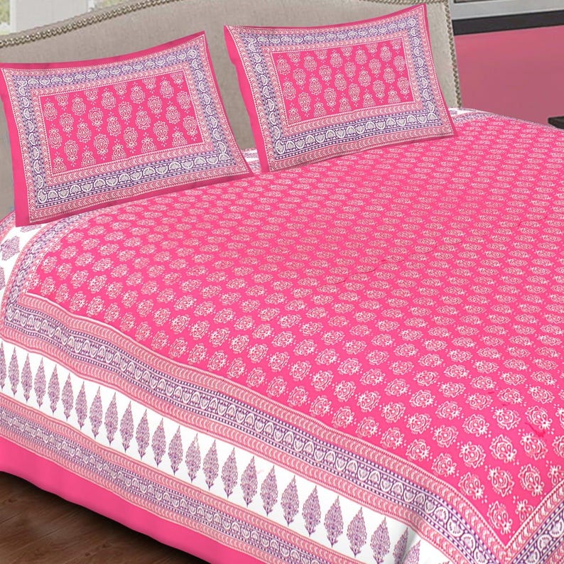 Peut inclure: Un ensemble de draps rose vif avec deux taies d'oreiller assorties. L'ensemble pr&eacute;sente un motif floral blanc r&eacute;p&eacute;t&eacute; sur le drap et les taies d'oreiller. Les taies d'oreiller ont une bordure d&eacute;corative avec un motif violet et blanc. L'ensemble de draps est en mati&egrave;re douce.