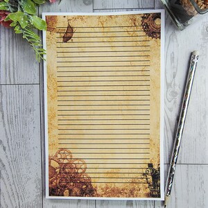 May include: A vintage-style lined paper sheet with a brown and beige background. The paper has a distressed look with faded gears and a leaf design. The paper is perfect for writing letters or journaling.