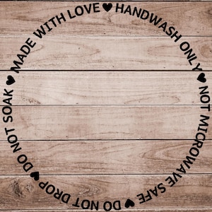Puede incluir: Un letrero de madera con un diseño circular que presenta el texto "MADE WITH LOVE♥ HANDWASH ONLY♥ DO NOT SOAK♥ DO NOT MICROWAVE SAFE♥ DO NOT DROP".