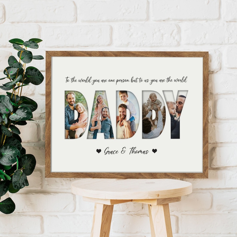 May include: A framed print with the word "DADDY" cut out, revealing family photos. The print has a wooden frame and includes the text "To the world you are one person but to us you are the world" and "Grace & Thomas".