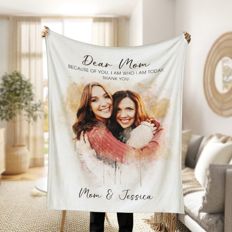 K&ouml;nnte beinhalten: Wei&szlig;e Fleece-Decke mit einem Aquarell-Foto von zwei Frauen, die sich umarmen. Der Text "Dear Mom Because of you, I am who I am today. Thank you. Mom & Jessica" ist auf der Decke aufgedruckt.