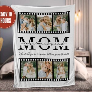 Op de afbeelding: Een wit fleece deken met een zwart-wit filmstripontwerp. Het deken heeft vier foto's van een vrouw met haar kinderen. De tekst "MOM" is geschreven in grote zwarte letters met de namen "Emily, Emma, Jorge, Noah" geschreven in cursief eronder. De tekst "To the world you are one person, but to us you are the world" is geschreven in zwart onder de namen.