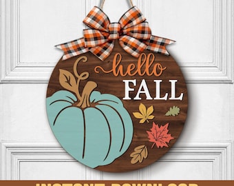 May include: A round wooden sign with a teal pumpkin and the words "hello FALL". The sign is decorated with fall leaves and a plaid bow. The sign is hanging by a twine string.