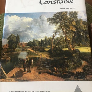 May include: A book cover with the title "Constable" in black cursive lettering. The text "Text by John Walker" is printed below the title. The cover features a painting of a landscape with a river, trees, and a path. The book has the text "148 reproductions with 57 in large full color" printed on the bottom left corner and the word "ABRAMS" printed on the bottom right corner.