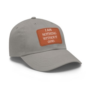 May include: A grey baseball cap with a brown leather patch that reads "I AM NOTHING WITHOUT GOD."