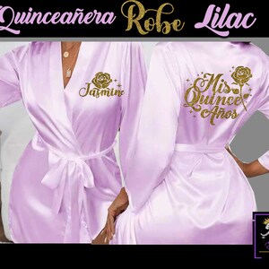 May include: Lilac satin robe with gold glitter lettering. The front of the robe says "Jasmine" and the back says "Mis Quince A&ntilde;os".