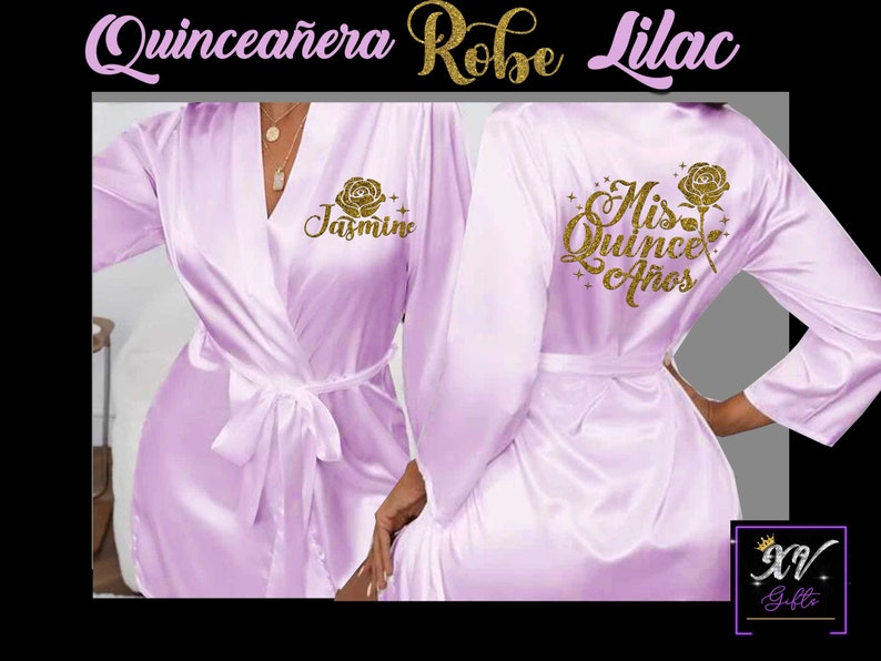 May include: Lilac satin robe with gold glitter lettering. The front of the robe says "Jasmine" and the back says "Mis Quince A&ntilde;os".