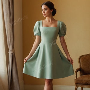 May include: A light green short-sleeved dress with a square neckline and a fitted bodice. The dress has a full skirt and is made of a smooth fabric.